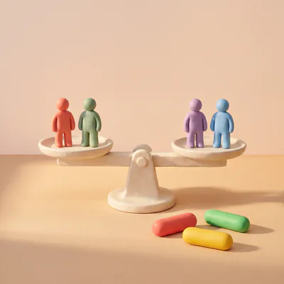 Une balance en pâte à l’équilibre, deux figurines debout sur chaque plateau.