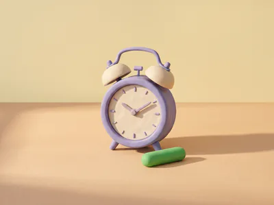 Un réveil à deux cloches en pâte, une pilule verte à son pied.